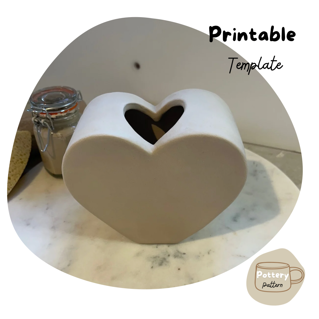 Handmade ceramic vase in a heart shaped with a heart shaped centre, displayed on a marble surface. part of a printable pottery template, ideal for creating personalized and unique pottery designs. 