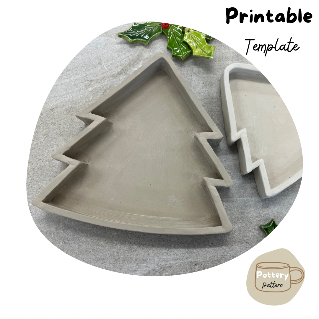 Handmade ceramic dish in the shape of a Christmas tree, shown in progress with smooth edges and a festive holly decoration nearby. Part of a printable pottery template for creating holiday- themed ceramic dishes.